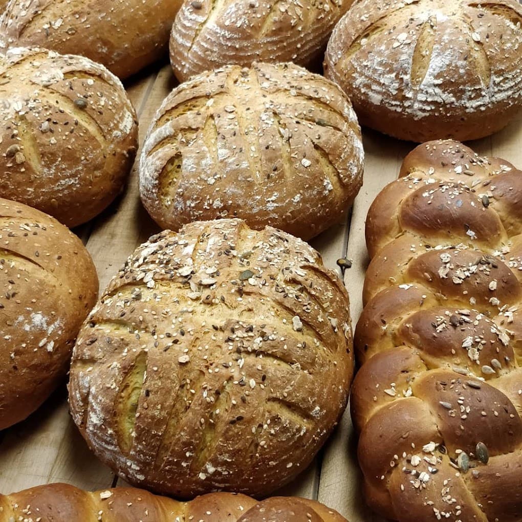 Seeded sourdough rounds and a braided loaf fresh from the Daves' Bakery ovens