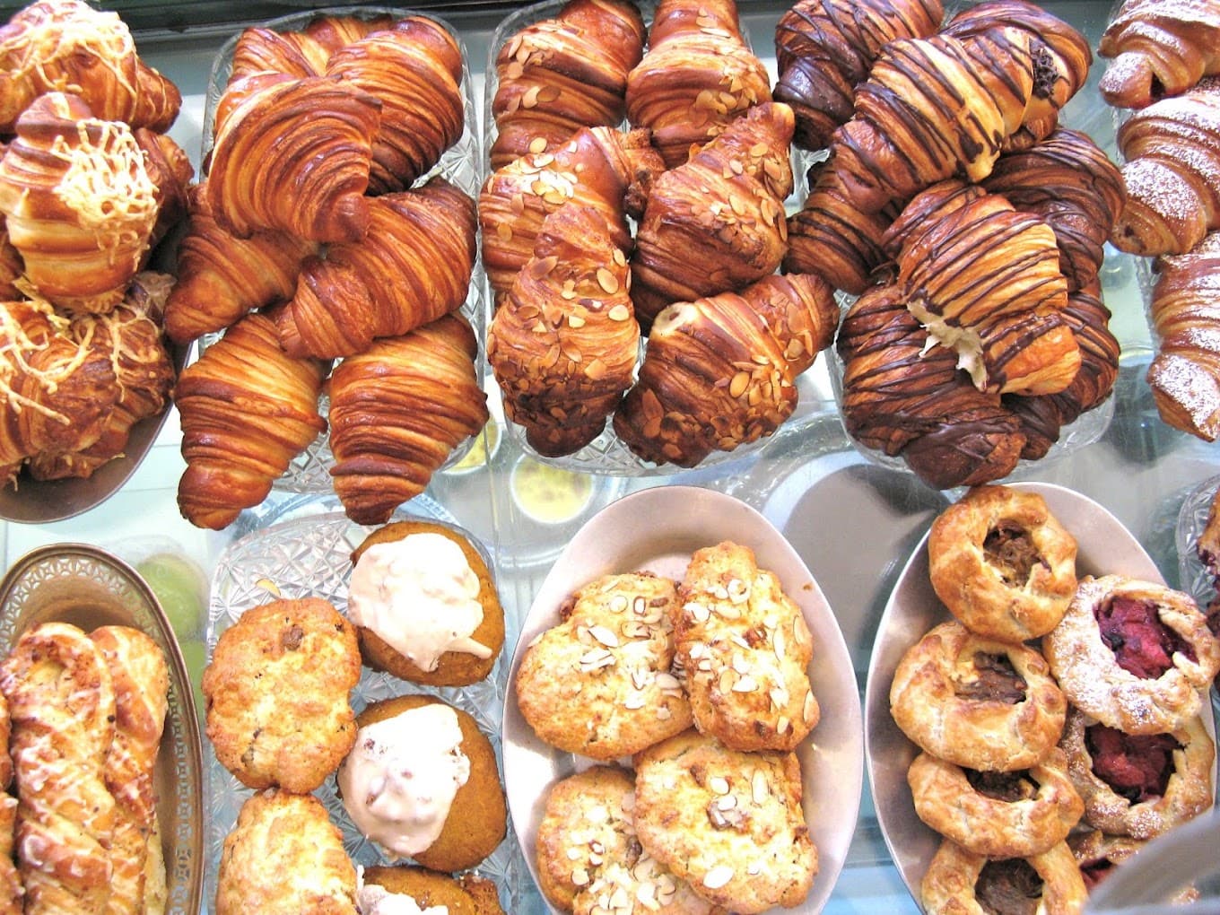 The pastry case stacked with croissants, danishes and fruit galettes