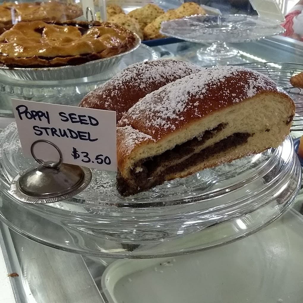 Poppy seed strudel dusted with icing sugar in the bakery case
